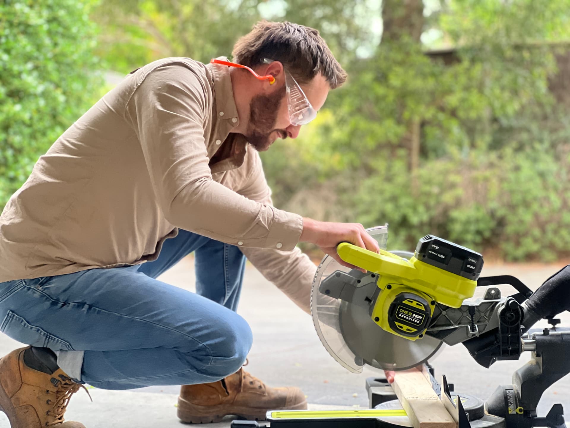 Karl Baldwin operating a miter saw on a bright outdoor DIY project